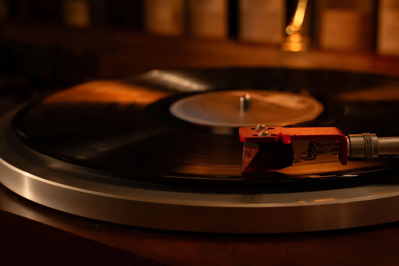 ターンテーブルの上で回るレコードと、赤いカートリッジ